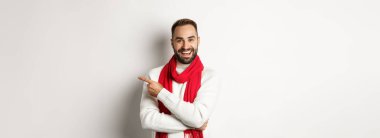 Noel tatili ve kutlama konsepti. Mutlu sakallı adam tam fotokopi alanını işaret ediyor, reklam teklifini gösteriyor, beyaz arka planda duruyor..