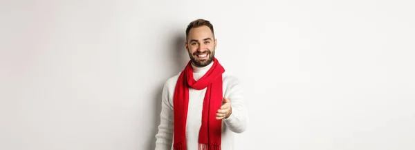 笑顔と願いを持つフレンドリーな若い男の挨拶の人メリークリスマス 赤いスカーフと冬のセーターを着て 白い背景 — ストック写真