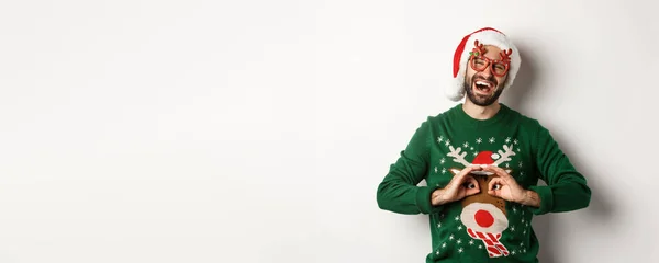 크리스마스 모자쓴 남자와 안경을 사람이 스웨터를 비웃고 있습니다 — 스톡 사진