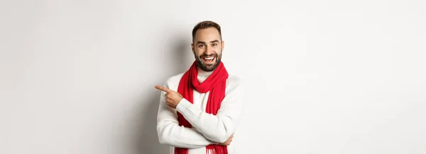 クリスマス休暇とお祝いの概念 幸せな髭を生やした男はコピースペースで指を指して広告を提供し白い背景の上に立っている — ストック写真