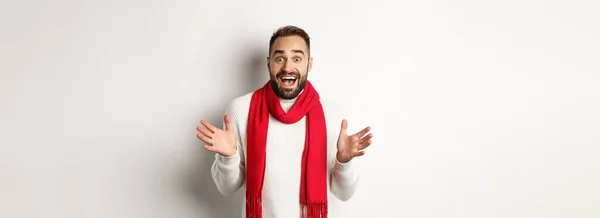 クリスマス休暇とお祝いの概念 ひげを生やした男見て驚いて新年のプロモーションオファー 息をのむ驚き 赤いスカーフとセーターを身に着けています 白い背景 — ストック写真