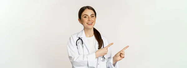 Mosolygó Fiatal Doktornő Egészségügyi Dolgozó Portréja Bal Oldali Ujjal Mutogatás — Stock Fotó