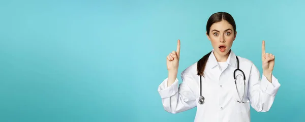 의사가 손가락을 치켜들고 놀라서 표정으로 광고를 거북의 위에서 — 스톡 사진
