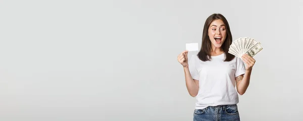 Amused Beautiful Girl Looking Money Holding Credit Card Standing White — Stock Photo, Image