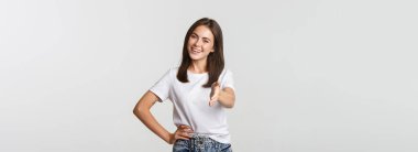 Gülümseyen, kendine güvenen genç kadın el sıkışmak için elini uzat, selamlayan kişi..