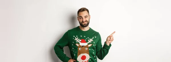 크리스마스 양복입은 남자는 보이고 제품을 손가락으로 가리키고 배경을 가리키며 — 스톡 사진