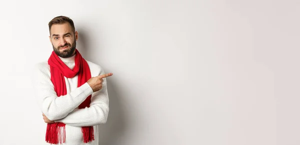 圣诞购物和寒假的概念 不高兴的人把手指指向右 对自己的不满意面带微笑 对自己的白人背景持怀疑态度 — 图库照片