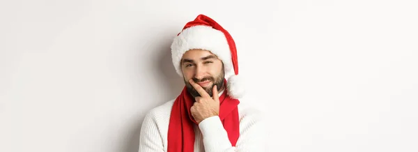 新年のパーティーや冬の休日のコンセプト サンタ ハットの髭の男のクローズアップは カメラ または意思決定を思慮深く見て クリスマスの贈り物 白い背景を選択してください — ストック写真