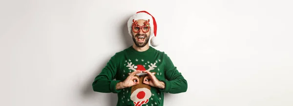크리스마스 모자쓴 남자와 안경을 사람이 스웨터를 비웃고 있습니다 — 스톡 사진