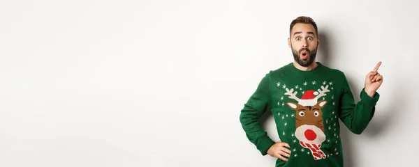 冬休みとクリスマス 白い背景に驚いて立って ロゴで指を指すように興奮している男 — ストック写真