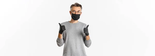 Covid パンデミックと社会的距離の概念 黒い医療用マスク 親指アップを示す眼鏡で中年の男のイメージは コロナウイルスをキャッチから身を守ります — ストック写真