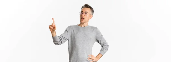 灰色のセーターと眼鏡で自信を持って中年のビジネスマンのイメージ 指を指し スピーチを行います 従業員にタスクを与えます 白い背景の上に立って — ストック写真
