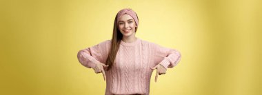 Genç, 20 'li yaşlarda, hırkalı, sırıtan Avrupalı bir kız nihayet yetenekli dişçi profesyonelini tanıtan diş tellerini indiriyor. Sarı duvarın üzerinde mutlu bir şekilde duran kız öğrenci..