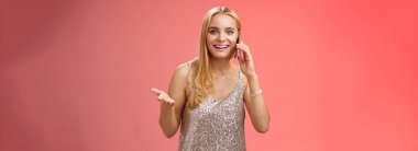 Neşeli, konuşkan, çekici, sarışın, arkadaş canlısı, akıllı telefondan konuşan, neşeli, neşeli, gümüşten yüzlü, partiden sonra yeni söylentiler anlatıp duran, gümüşten şık elbiseler giyen, kırmızı arka plan..