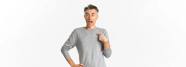 灰色の基本的なセーターの上に白い背景に立って 選択されて 自分自身を指して 驚いて見てハンサムな中年ゲイの男の肖像画 — ストック写真