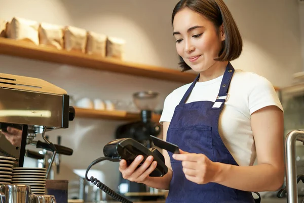 かわいいアジアの女の子 非接触決済を処理するカフェでバリスタ Pos端末にクレジットカードを挿入 コーヒーショップで注文を取る — ストック写真