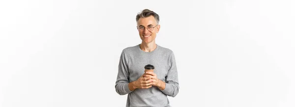 黒髪のハンサムな中年男性のイメージ 眼鏡とグレーのセーターを身に着けています コーヒーを飲み 喜んで笑顔 白い背景の上に立って — ストック写真
