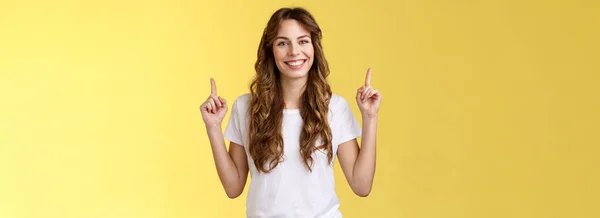 自信自信 迷人的欧洲高个子姑娘 展示了她的建议 酷酷的宣传品 指尖着食指 微笑着 喜形于色的演出者 精彩的广告黄色背景 — 图库照片