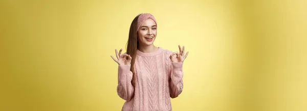 積極的な魅力的なアップビート若いかわいいヨーロッパの女性で20代のカジュアルなセーターを身に着けています ヘッドバンドショー大丈夫 Okジェスチャー笑顔すべてを保証します 黄色の壁に自信を持って罰金笑顔 — ストック写真