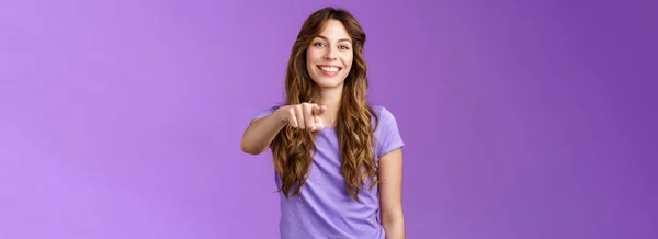 快乐的女孩指着你 迷人的 友善的 快乐的 卷曲的 头发的女性 决定谁选谁 手指相机笑着快乐地邀请同事站在紫色的背景上 — 图库照片