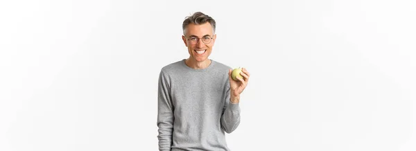 照片中快乐英俊的中年男人 露出绿色的苹果 站在白色的背景上 — 图库照片