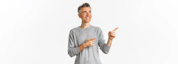 Obraz Uśmiechniętego Przystojnego Mężczyzny Średnim Wieku Patrzącego Logo Wytykającego Palcami — Zdjęcie stockowe