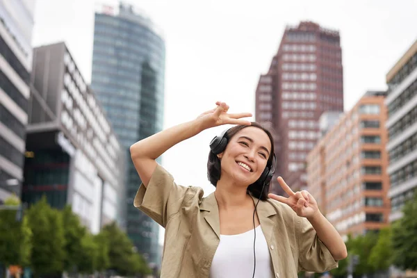 Счастливая Азиатка Наушниках Слушающая Музыку Танцующая Улице Центра Города Улыбающаяся — стоковое фото