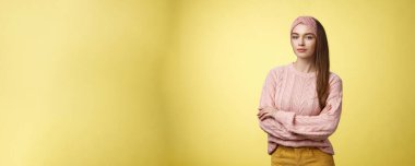 Dene bakalım. Kendine güvenen, kendine güvenen, sırıtan, kendine güvenen, kendine güvenen genç, çekici bir kadın kuaför. Sarı arka planda poz veren kız öğrenci teşvik edildi.