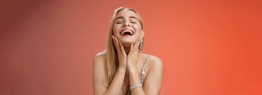 Yaşam tarzı. Mutlu, neşeli, başarılı, çekici, sarışın, gümüş renkli, şık gece elbisesi giyen, yanaklarına dokunan mutlu, gülen, kaygısızca gülen, yakın gözler.