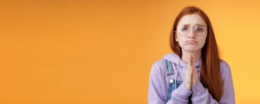 Yalvarırım. Yapışkan üzgün, üzgün, beyaz saçlı, gözlüklü, somurtan, somurtan, suratını buruşturan, yardım isteyen, acilen bir şey ödünç almak isteyen, turuncu arka plan..