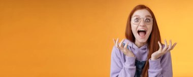 Şok olmuş genç, şaşkın, çığlık atan, gözlüklü, mutlu, gözlüklü kız kazanıyor. Harika haberler bağırıyor, seviniyor..