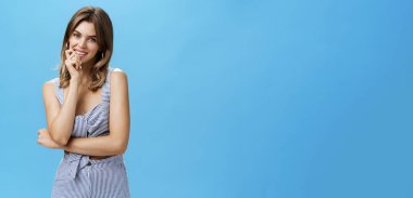 Moda eşleşen giysiler içinde çekici genç bir kadının portresi. Sanki mavi arka planda sırıtırken tatlı diyastema göstermeyi aklından geçiriyormuş gibi duygusal bir gülümseme. Doğal güzellik.