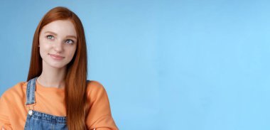 Zeki, yaratıcı, güzel, kızıl saçlı, serbest çalışan kadın sol üst köşeye dikkatlice bak sırıtarak karar verme, makyaj yapma, kendine güvenen eller göğüs mavisi arka planda..
