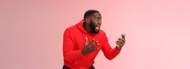 Desparate angry pissed african-american irritated man yelling smartphone look angry phone display gesturing dismay anger, furious lose last level hard game, standing bothered outraged.