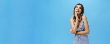 Ha-ha çok komik. Gülen, gülümseyen, gülen, ağzı açık, avucu açık, mavi duvarda poz veren mutlu ve keyifli bir kadın portresi..