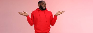 Afro-amerikan adam başını sallıyor kaşlarını çatmadan suratını buruşturuyor omuz silkip duran ellerden hoşlanmıyor tatminsiz, tatminsiz bir soru soruyor, cahil pembe arka plan.