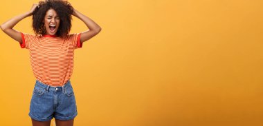 Hayatın zalim olmasından nefret ediyorum. Depresyonda olan Afrikalı kadın öfkeden kudurmuş saçlarını başını yoluyor bağırıyor, çığlık atıyor gözleri kapalı, öfkesini kaybediyor turuncu duvardaki her şeyden nefret ederek kötü bir gün geçiriyor..