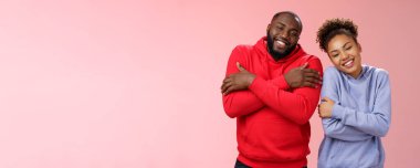 İki afro-amerikan erkek çifti birbirlerini kucaklarken rahat hissediyorlar. Mutlu bir şekilde sarılıyorlar. Sevgi dolu görünüyorlar..