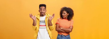 Tanrım, senin sorunun ne? Gücenmiş Afro-Amerikan stili ve çekici kız arkadaşı erkek arkadaşına bakıyor, havalı davranıyor üzgün omuz silkiyor ve gülümsüyor numarası yapıyor.