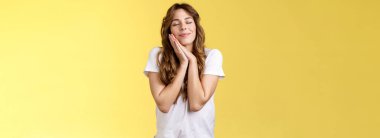 Dertsiz tasasız, büyüleyici Avrupalı kadın kıvırcık saçlı, uzun saçlı, gözleri kapalı neşeli bir şekilde gülümseyen, hayal kuran, olumlu anıları canlandıran, güzel hatıraları hatırlatan, uykulu bir uyku tutumu olan. Yaşam biçimi.