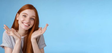 Aptal, sevimli, samimi, Avrupalı, genç, kızıl, mavi gözlü kız ellerini silkip, yüzün yakınına yayılmış, özür dileyen, yaltaklanan, özür dileyen, geç kalan, aptalca bahaneler üreten, mavi arka plan..