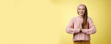 Lütfen bana bir iyilik yap. Büyüleyici genç bayan öğrenci örülmüş süveter giyiyor, saç bandı takıyor dua etmek için avuç içlerine bastırıyor, yalvarıyor, gülümsüyor şükran duyuyor, sarı duvardaki çabası için minnettar..