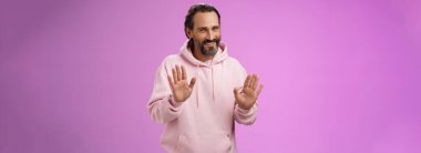 Teşekkür kartı yok. Yakışıklı, kibar, yetişkin, sakallı, pembe kapüşonlu gri saçlı, özür dileyen, reddeden, reddeden, gülümseyen, üzgün, ilgilenmeyen, mor arka planlı adam..