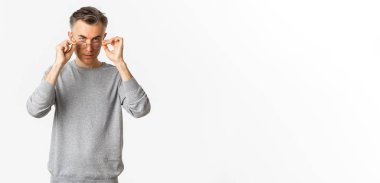 Gri kısa saçlı, yakışıklı ve kendinden emin orta yaşlı bir adamın görüntüsü. Gözlüklerini takıp kameraya ciddi bir şekilde bakıyor. Beyaz arka planda duruyor..