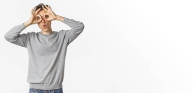 Orta yaşlı komik bir adamın portresi. Surat yapıyor, gözlük takıyor, etrafta takılıyor, beyaz arka planda dikiliyor..