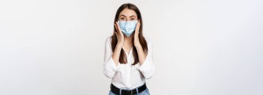 Surprised woman in face medical mask looking amazed, checking out awesome news, big reveal, standing over white background.