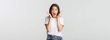 Şaşırmış ve şaşırmış esmer kız nefes nefese, düşük çene etkilenmiş.