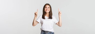 Çekici, gülümseyen esmer kız parmaklarını kaldırıp logoyu gösteriyor..