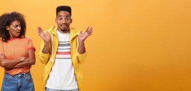 Tanrım, senin sorunun ne? Gücenmiş Afro-Amerikan stili ve çekici kız arkadaşı erkek arkadaşına bakıyor, havalı davranıyor üzgün omuz silkiyor ve gülümsüyor numarası yapıyor.