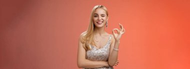 Şık, lüks, gümüş elbiseli, şımarık sarışın bir kadın her şeyi kontrol altına alıyor. Tamam, sorun yok..